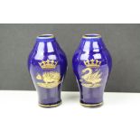 A pair of continental blue vases with stylized animal crests.