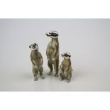 A collection of three enamel and hallmarked silver meerkat figures.