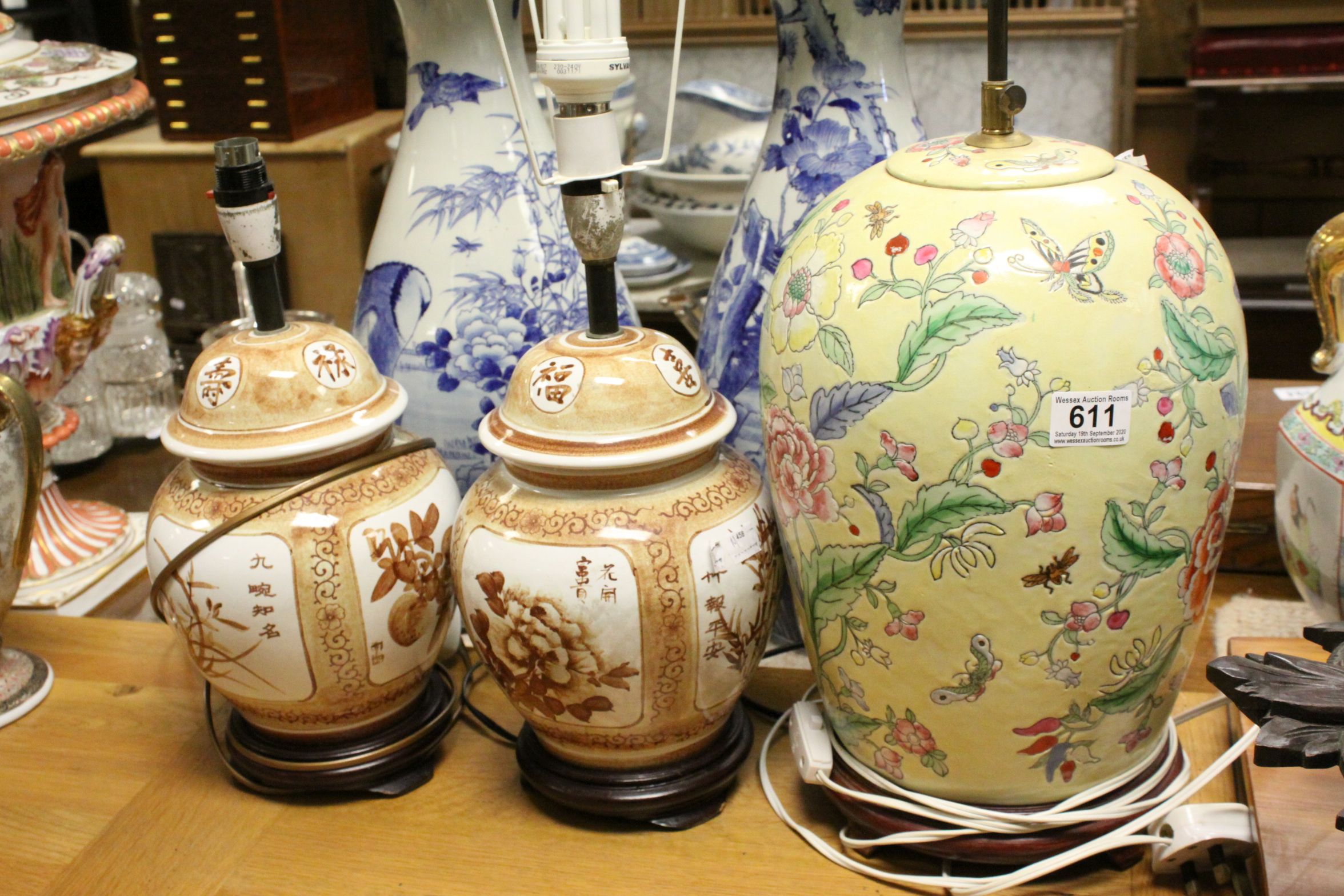 A pair of oriental lidded vases converted to lamps together with similar Famille Rose lamp.