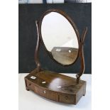 19th century Mahogany Oval Swing Mirror, the bow front base with three drawers (a/f), 62cms high