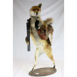 Taxidermy Fox standing on it's hind legs and holding a Taxidermy Pheasant and carrying a replica
