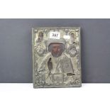 An antique Russian religious icon painted to wooden panel with decorative brass overlay.