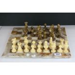 Carved stone chess set together with similar board.