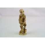 Japanese carved ivory figure of a farmer holding a rabbit in a basket with trailing fruit, signed,