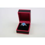 A silver CZ and blue opal teardrop shaped ring.
