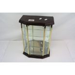 A small table top glass fronted collectors cabinet with mirrored shelves.