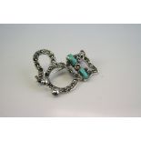 A silver marcasite and turquoise car brooch.