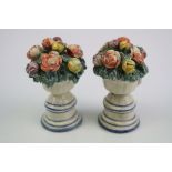 A pair of continental miniature pottery tin glazed urns with flowers.