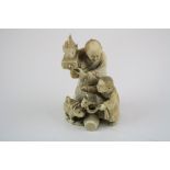 A Meiji Japanese ivory group of father and son, signed, the father holding a fish aloft on a