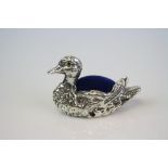 A silver swan pincushion.