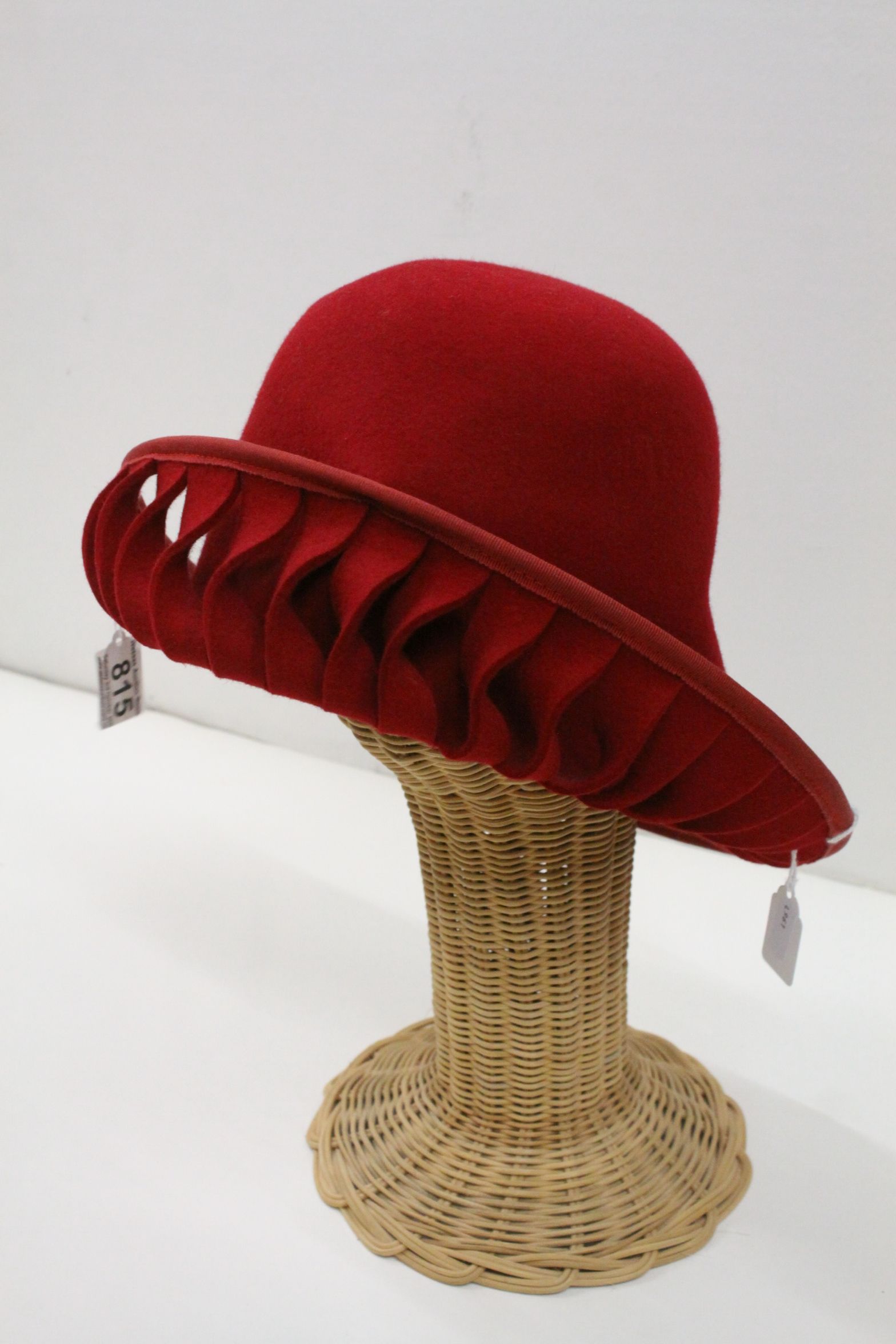 Elvis Pampilio Bruxelles, asymetric red felt hat with pierced twist design border together with