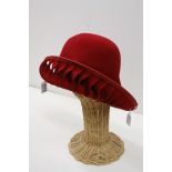 Elvis Pampilio Bruxelles, asymetric red felt hat with pierced twist design border together with