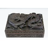 A 19th century Chinese carved wooden cigar box, the hinged lid decorated in high relief with the a