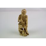 Japanese carved ivory group of a fisherman and a young boy, signed in red script below, losses to