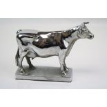 A vintage chromed car mascot in the form of a cow.