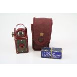 A vintage red marbled bakelite Coronet Midget camera together with a miniature mouth organ.