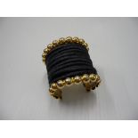 Nina Ricci cuff bangle, woven black banding with large gold coloured balls to borders (one ball