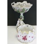 A continental ceramic table centrepiece decorated with embossed flowers and figures together with