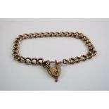 A 9ct rose gold charm bracelet with heart lock, marked 9ct to each link.