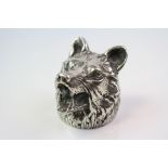 A white metal bottle opener in the form of a wolfs head.