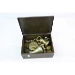 A collection of vintage brass weights contained within a decorative metal box.
