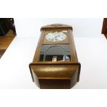 A 20th century Kleniger oak cased wall clock with pendulum.