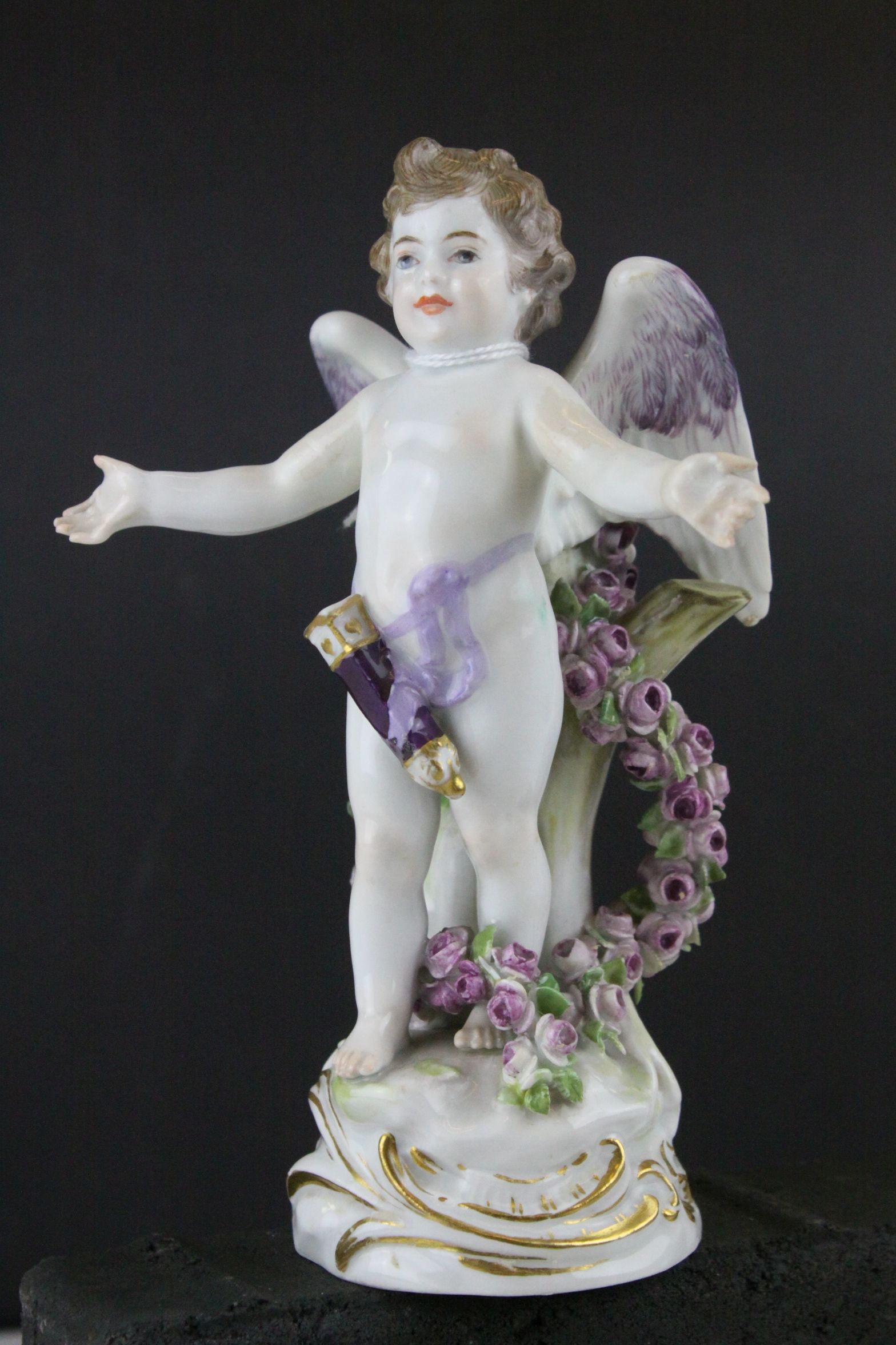 Meissen Porcelain Figure of Cupid with open arms, the base decorated with gilt scrolls, blue cross
