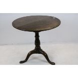 George III Oak Circular Tripod Table, tilt top with Bird Cage movement raised on a baluster stem and