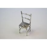 A silver figure of an antique chair