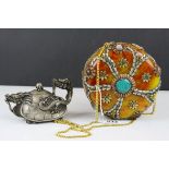 A faux stone purse with brass inlay and set with polished stones,and a white metal dragon teapot