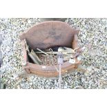 A cast iron fire basket with tools.