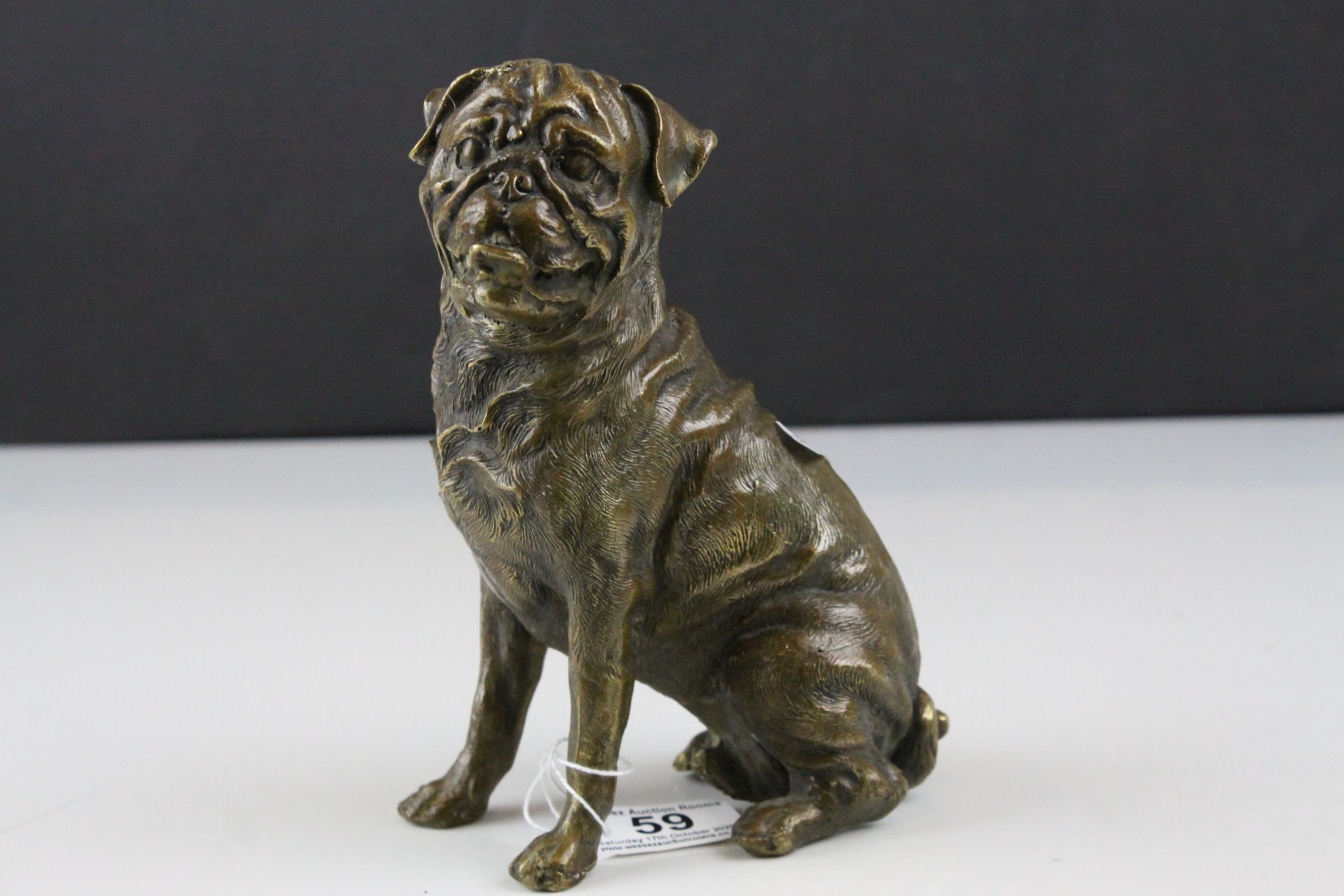 A bronze seated Mastiff dog figure 18 cm tall.