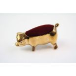 A brass pig pincushion