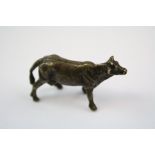 A small bronze/brass figure of a cow.