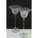 A pair of hobnail glass candle holders with long stems raised on a circular base together with a