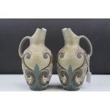 A pair of Doulton Lambeth Silicon late 19th century jugs with scrolling decoration by various