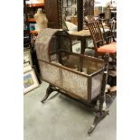 19th century Mahogany Crib with Bergere Sides, the swing cradle held on a turned and block frame,