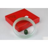 Pale jade bangle, width approximately 13mm together with a jade type polished bead, length