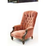 Victorian Button Back Upholstered Armchair with carved scroll arms and raised on bulbous front