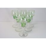 Set of six green and clear glass wine glasses decorated with roundels raised on a graduated