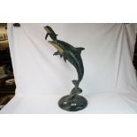 A large bronze sculpture of a Dolphin with young leaping raised on a circular marble base. 63 cm
