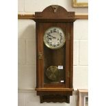An oak cased wall clock with two train movement.