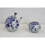 A blue and White oriental teapot with integral strainer and one other similar.