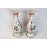 A pair of continental vaseline glass vases with floral decorated panels.26 cm in height.