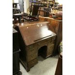 Mid 18th century Oak Kneehole Bureau with stepped fitted interior, book rest, eight short drawers