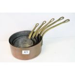 A set of five graduating Copper Saucepans with brass handles