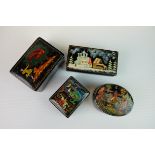 Four Russian Black Lacquered Trinket Boxes, each with painted design to lid, largest 8cms long