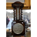 A 20th century oak cased barometer with barley twist supports.