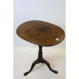 George III Mahogany Oval Tilt Top Table, raised on turned column support and three splaye legs,