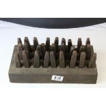 A set of vintage cast iron letter punches with stand.